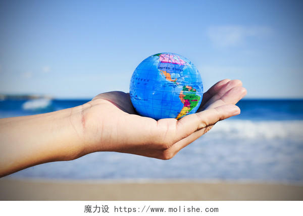 蓝色天空下一个手握着地球仪世界卫生日